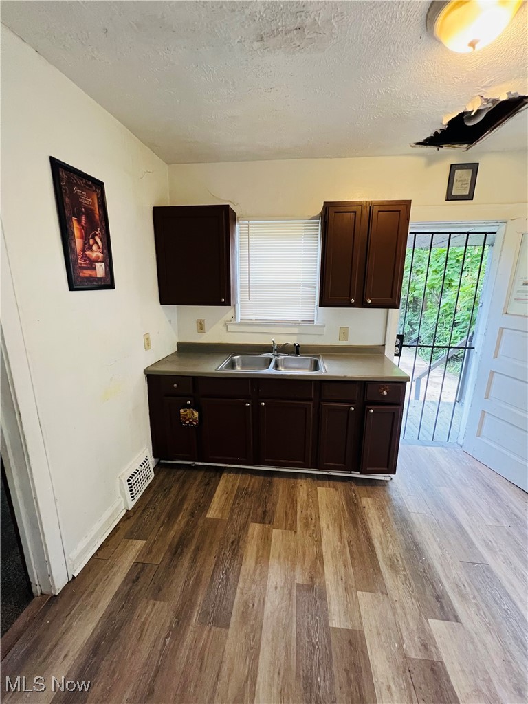 968 Whitby Road Cleveland Heights, OH 44112 - Photo 5 of 19 Kitchen with dark brown cabinets, a textured ceiling, plenty of natural light, and dark wood-style floors