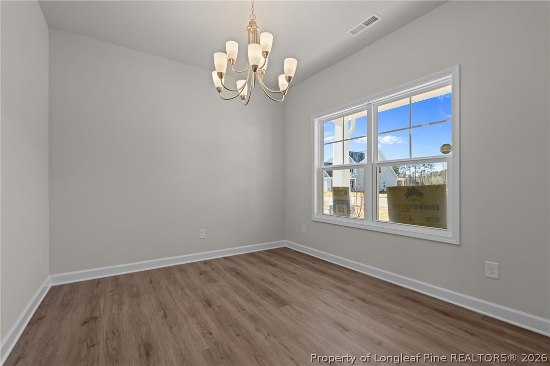 290 Elijah Way Vass, NC 28394 - Photo 11 of 45 a view of an empty room with a window and wooden floor