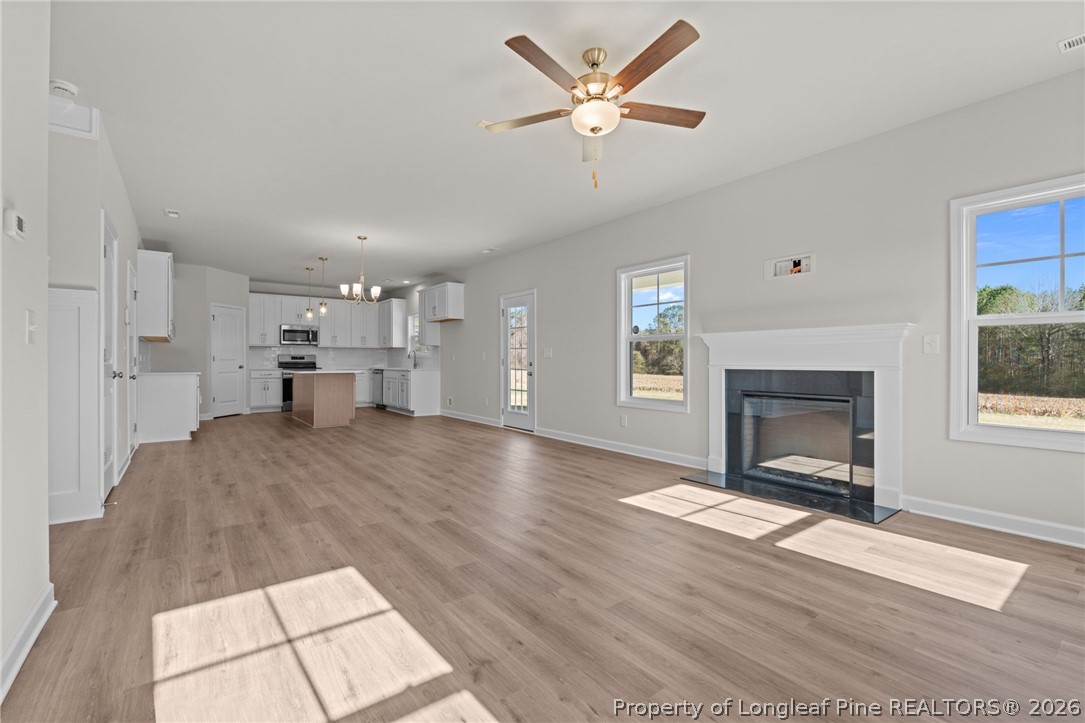 290 Elijah Way Vass, NC 28394 - Photo 15 of 45 a view of a livingroom with a fireplace a ceiling fan and windows