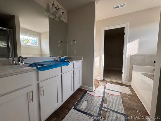 a spacious bathroom with a sink a mirror a toilet and a shower