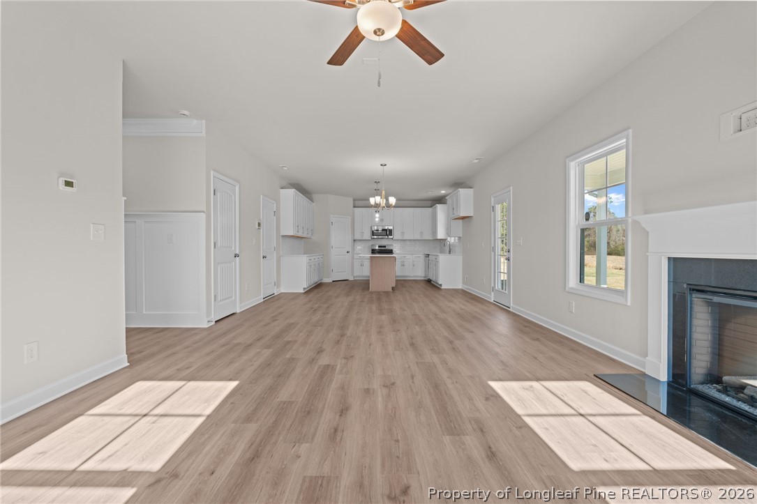 290 Elijah Way Vass, NC 28394 - Photo 16 of 45 a view of empty room with wooden floor and fireplace