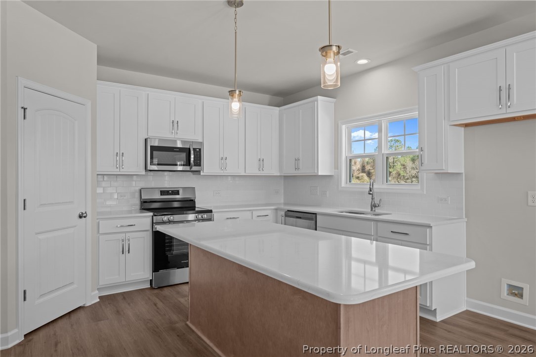 290 Elijah Way Vass, NC 28394 - Photo 21 of 45 a kitchen with stainless steel appliances granite countertop a sink stove and refrigerator