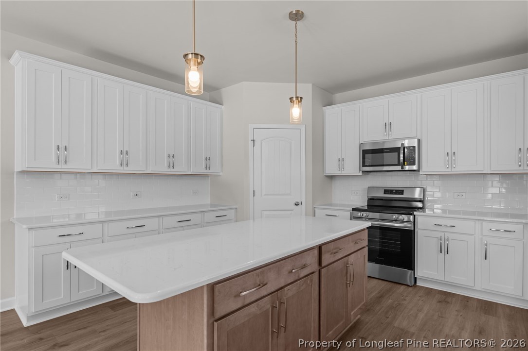 290 Elijah Way Vass, NC 28394 - Photo 23 of 45 a kitchen with cabinets stainless steel appliances and wooden floor