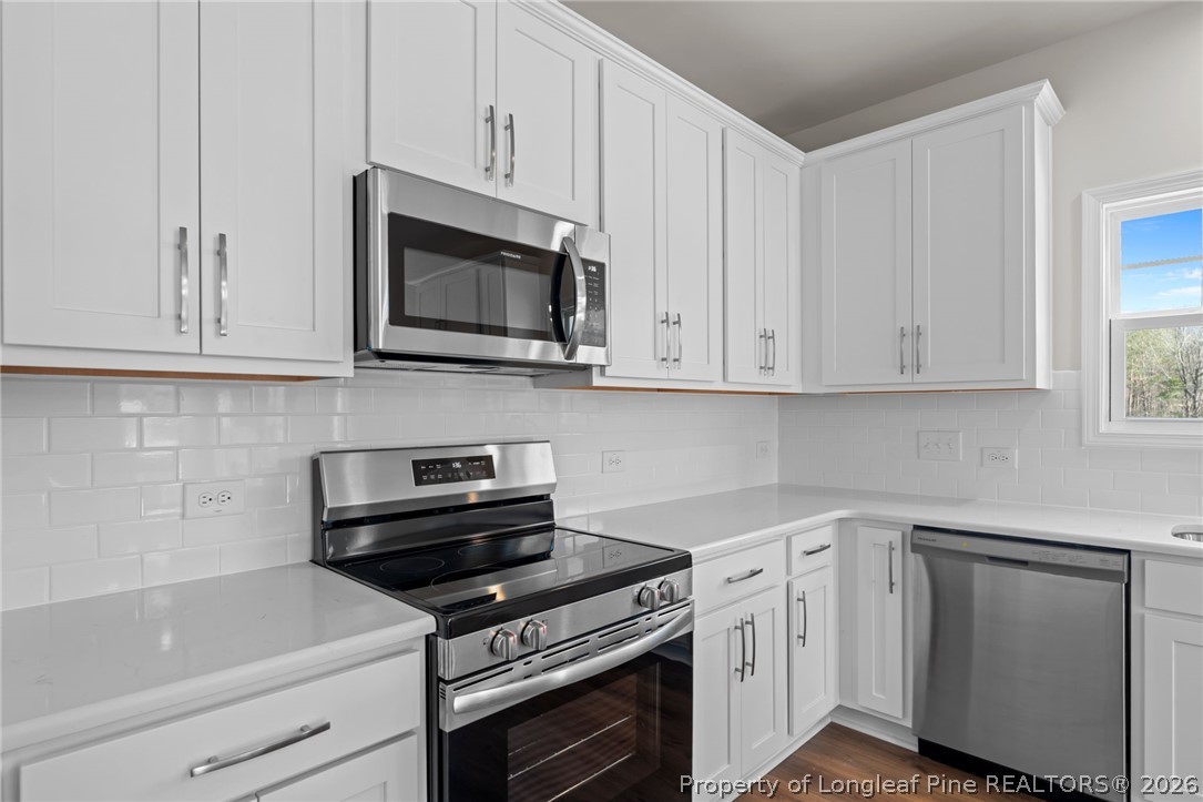 290 Elijah Way Vass, NC 28394 - Photo 25 of 45 a kitchen with white cabinets and stainless steel appliances