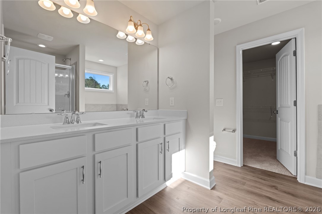 290 Elijah Way Vass, NC 28394 - Photo 30 of 45 a bathroom with a double vanity sink and a mirror