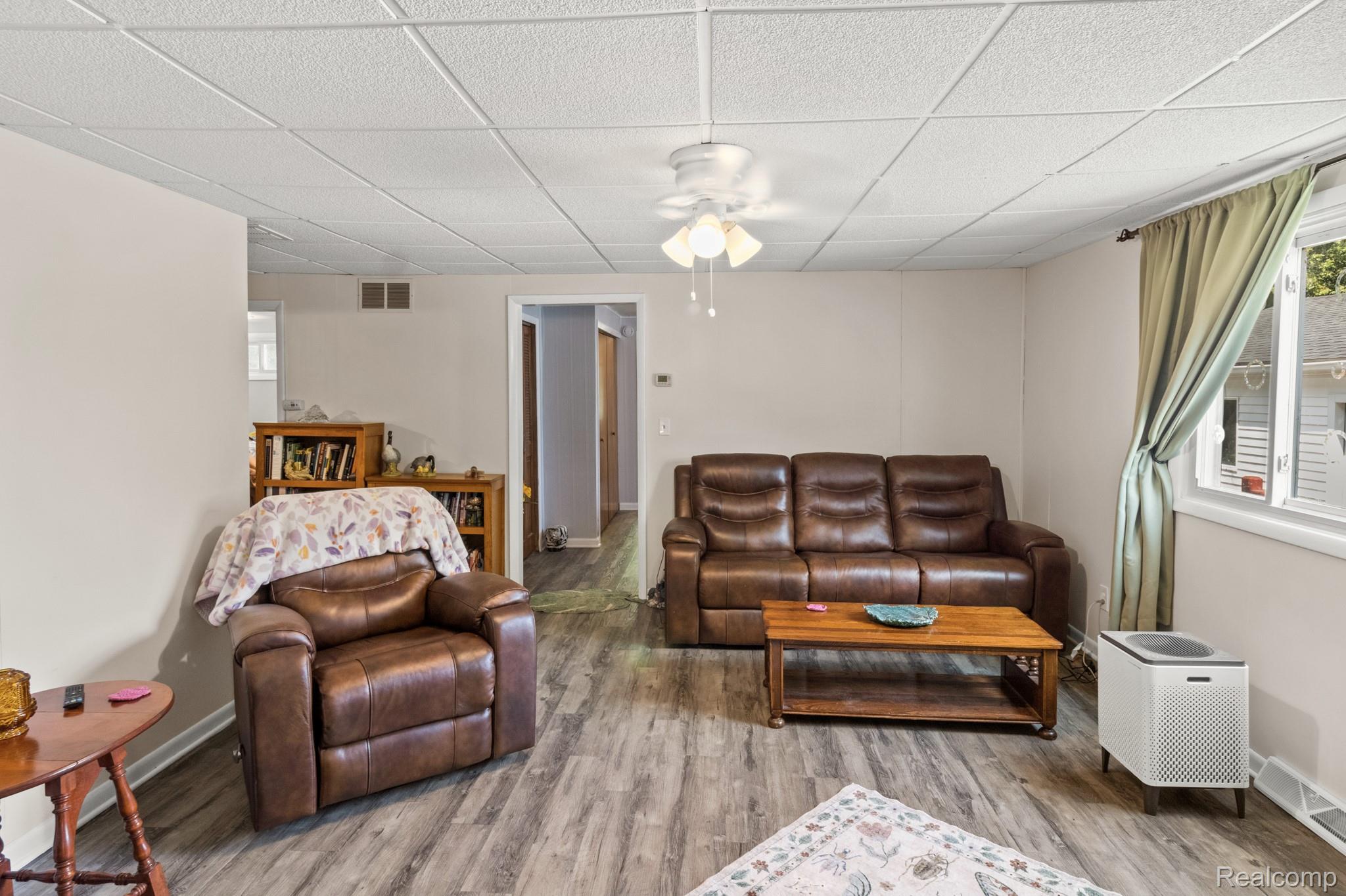 7330 Embury Road Grand Blanc, MI 48439 - Photo 17 of 29 Spacious living area featuring wood-finish flooring, neutral wall tones, a ceiling fan, and ample natural light from a double-pane window