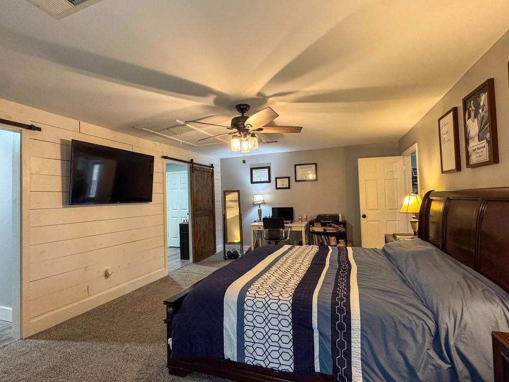 127 Walton Loop Covington, TN 38019 - Photo 17 of 40 a bedroom with a large bed a flat tv screen and large dresser