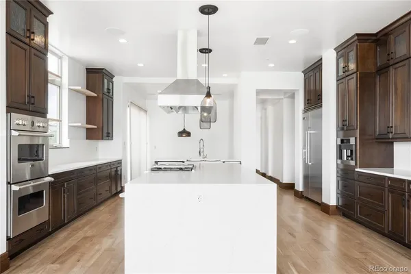 a large kitchen with stainless steel appliances a refrigerator a stove a sink and a stove