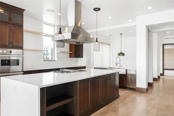 a kitchen with stainless steel appliances granite countertop a sink a stove and a refrigerator