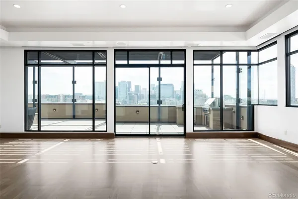 a view of empty room with wooden floor and floor to ceiling window