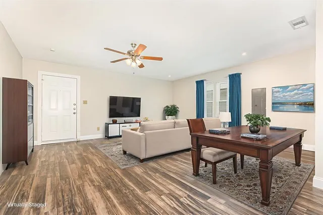 a living room with furniture a flat screen tv and a large window