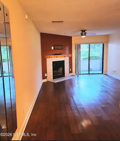 a view of empty room with wooden floor and fireplace