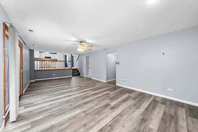 a view of a livingroom with wooden floor and a ceiling fan