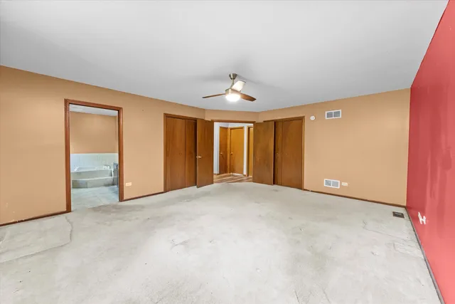 a view of an empty room with window and stairs