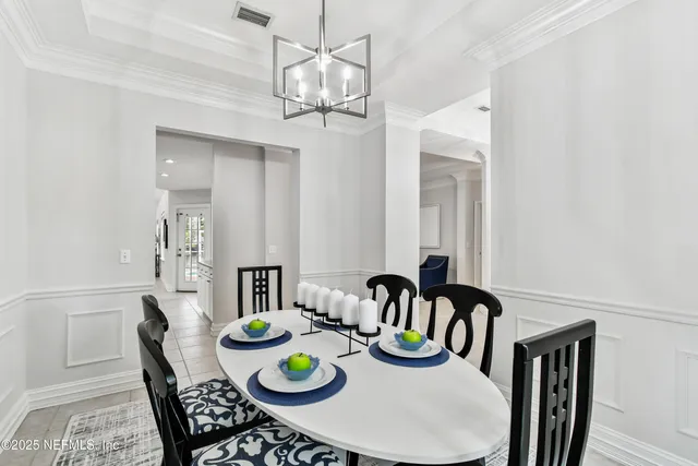 a kitchen with stainless steel appliances granite countertop a refrigerator a stove a sink a dining table and chairs