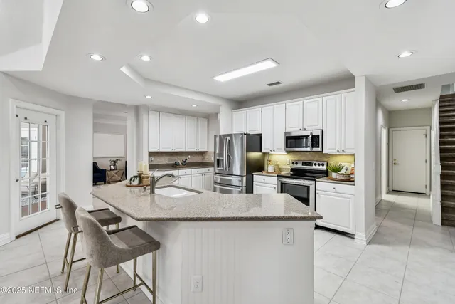 a bathroom with a granite countertop sink a toilet and a mirror