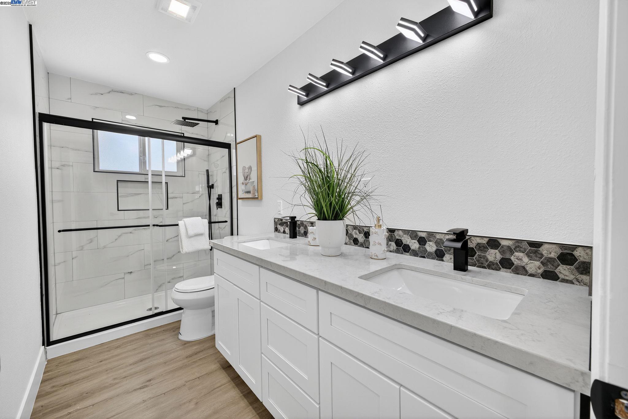4403 Burke Way Fremont, CA 94536 - Photo 28 of 58 a bathroom with a granite countertop sink a toilet and shower