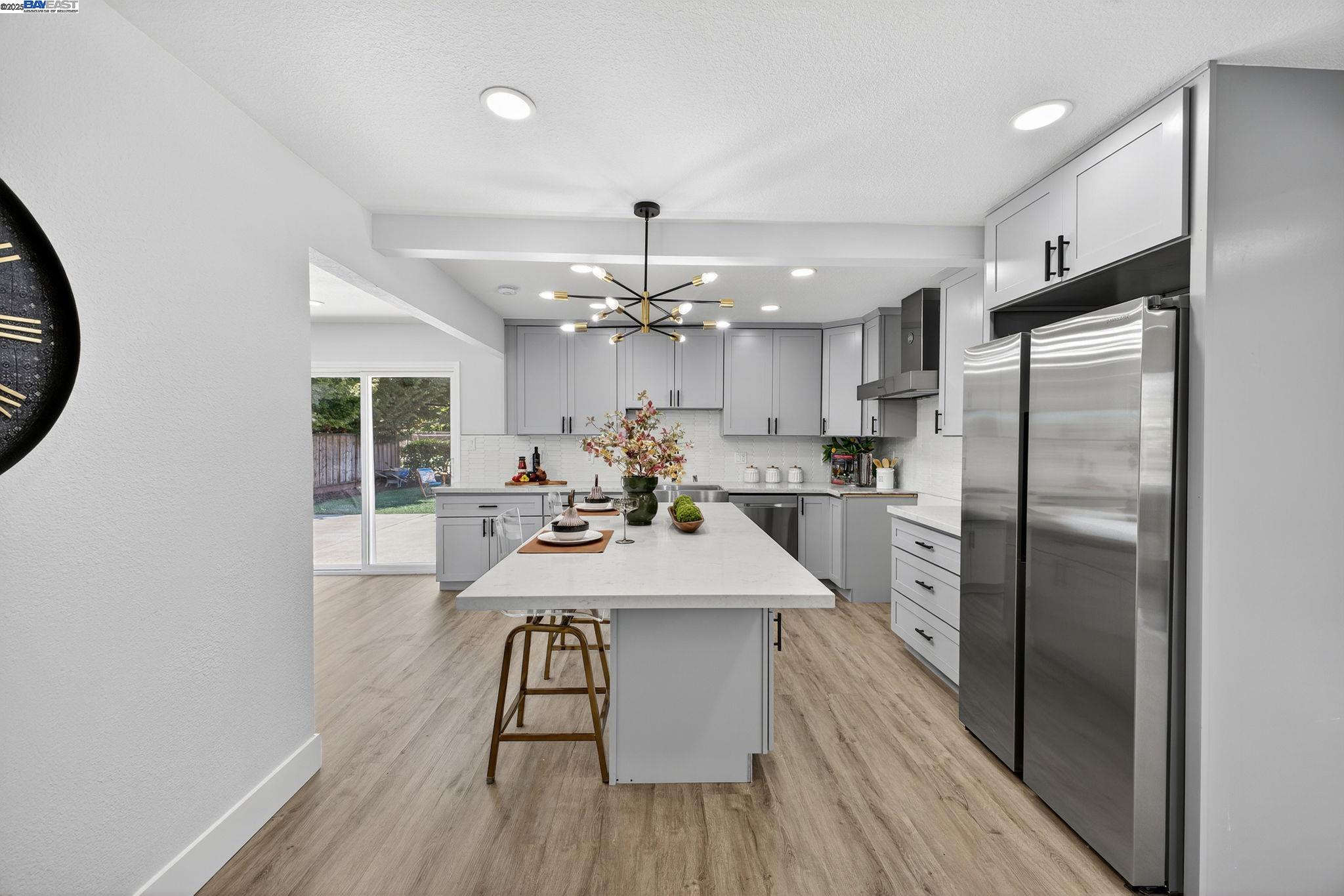 4403 Burke Way Fremont, CA 94536 - Photo 8 of 58 a kitchen with stainless steel appliances a dining table chairs refrigerator and cabinets