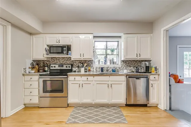 a kitchen with stainless steel appliances granite countertop a stove a sink and a microwave