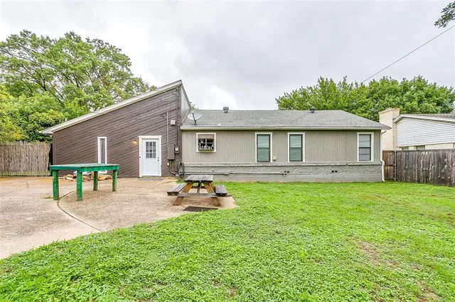 a backyard of a house with table and chairs