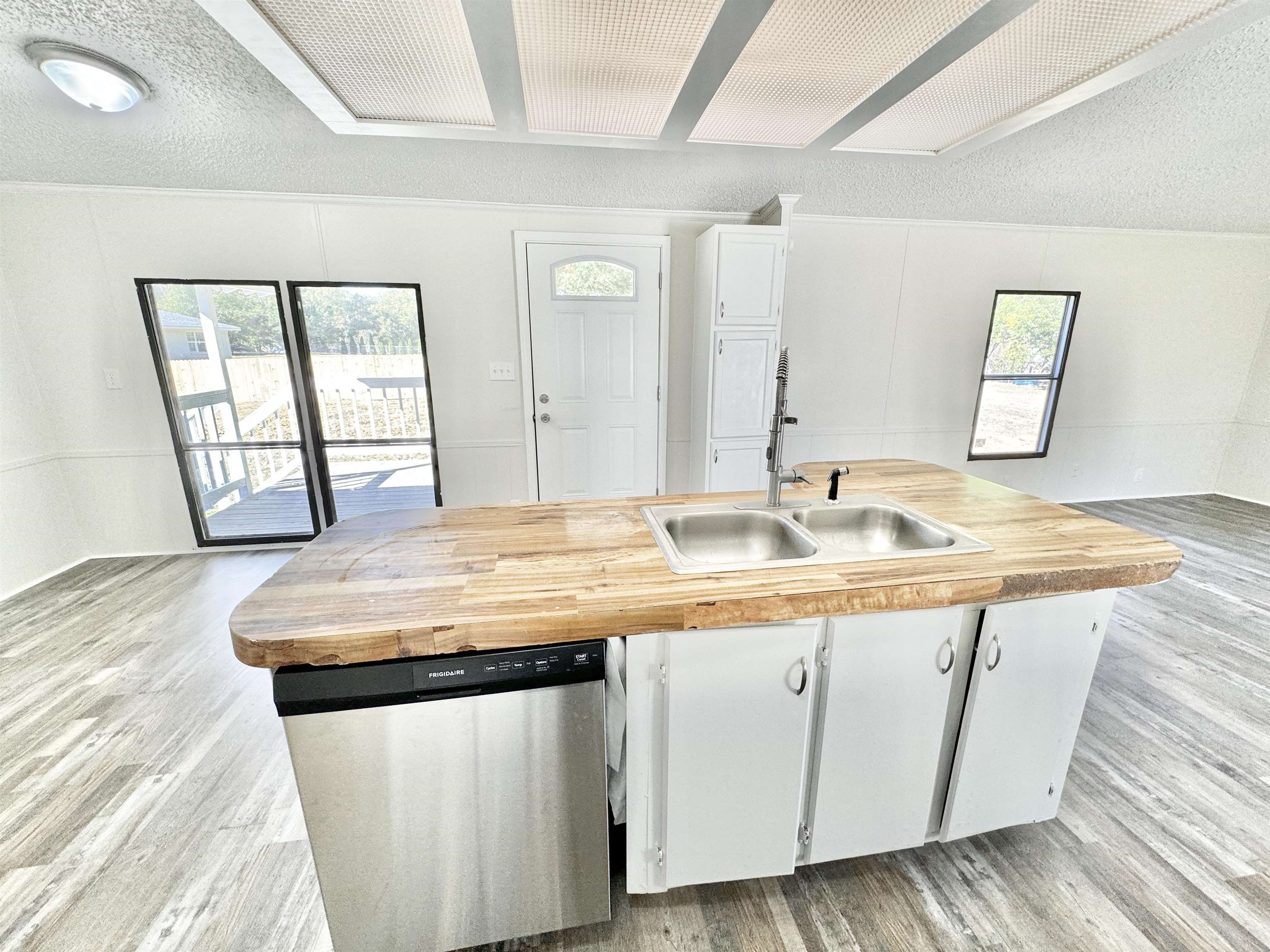 285 Hicks Road Oakland, TN 38060 - Photo 13 of 24 Kitchen featuring white cabinets, a textured ceiling, stainless steel dishwasher, light hardwood / wood-style floors, and sink