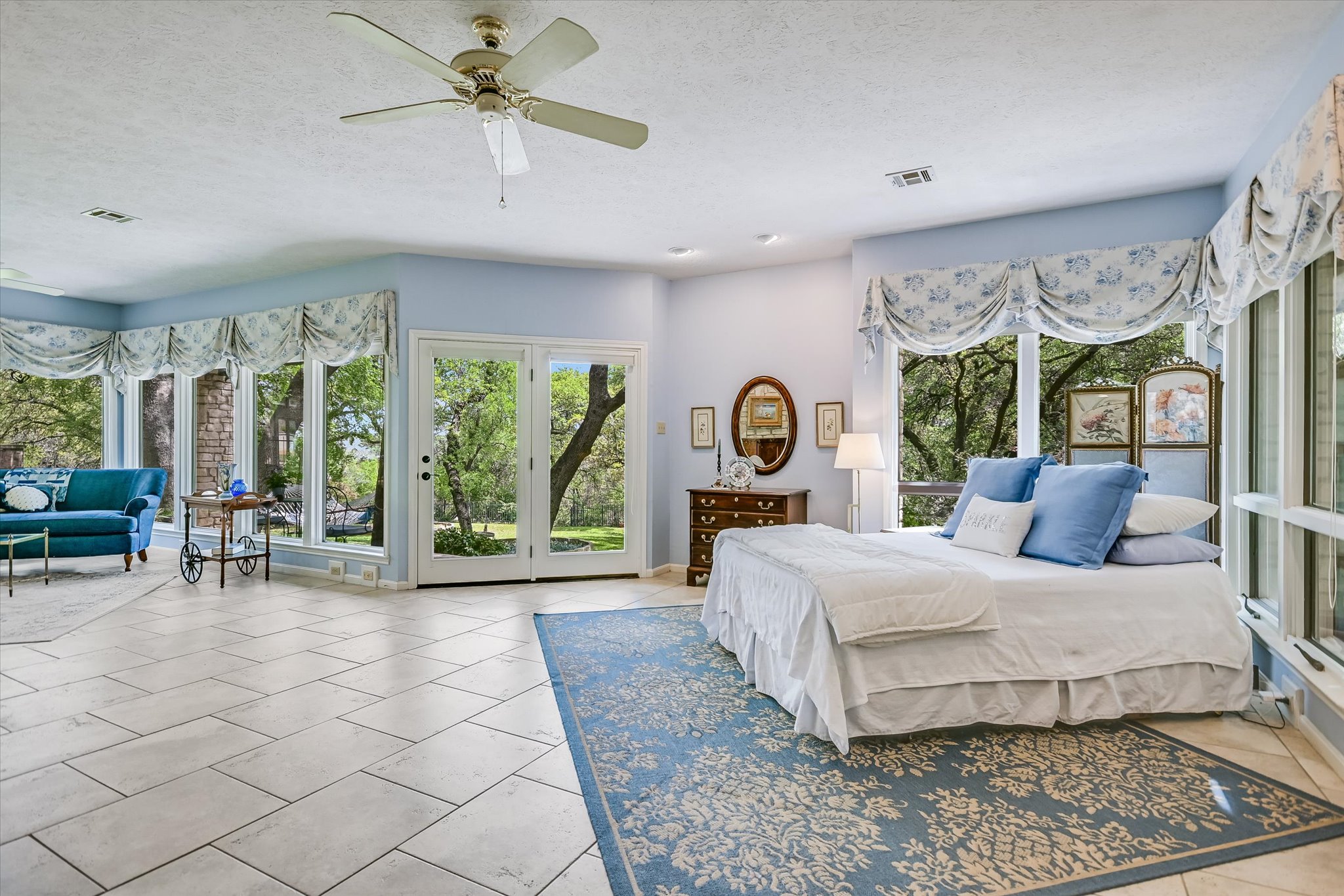 3901 Prentice Lane Austin, TX 78746 - Photo 12 of 40 The spacious primary bedroom is filled with natural light and peaceful views of the surrounding trees.