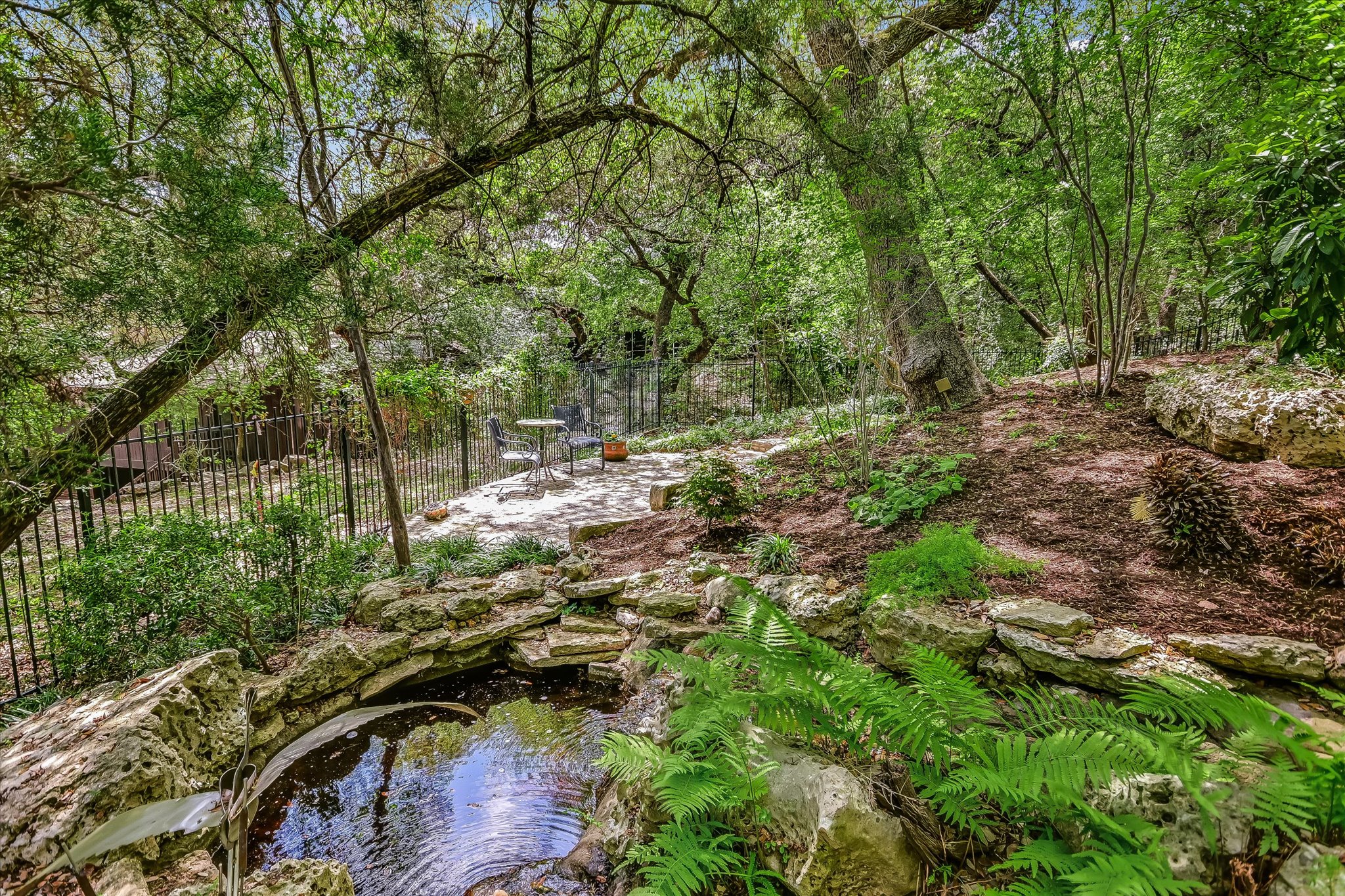 3901 Prentice Lane Austin, TX 78746 - Photo 25 of 40 The flowing water feature and pond create a calming focal point within the landscape.