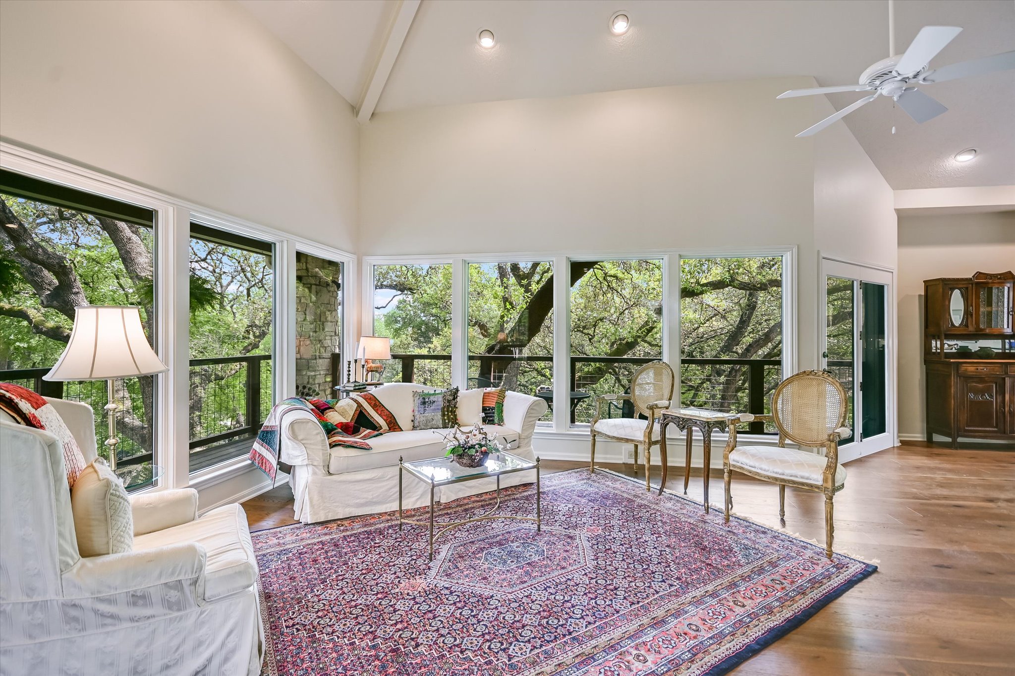3901 Prentice Lane Austin, TX 78746 - Photo 5 of 40 Walls of windows invite natural light inside and frame peaceful views of the surrounding trees.
