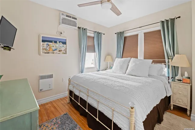 a bedroom with a bed and a flat tv screen on dresser