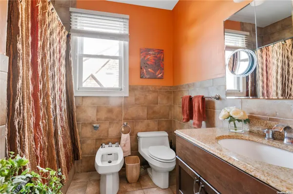 a bathroom with a granite countertop toilet a sink and a mirror