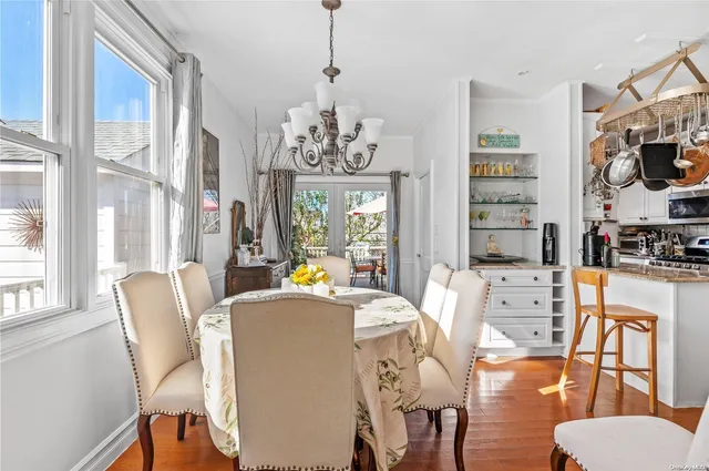 a view of a dining room with furniture a chandelier and wooden floor