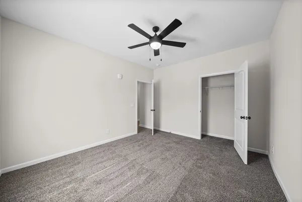 a view of an empty room with a ceiling fan