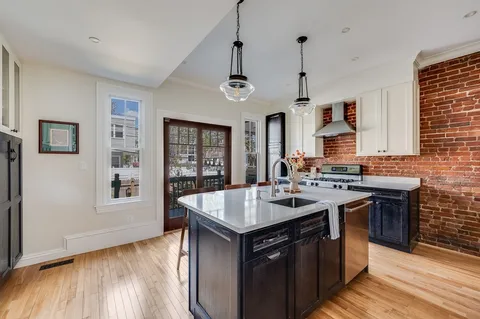 a kitchen with granite countertop a sink stove and cabinets