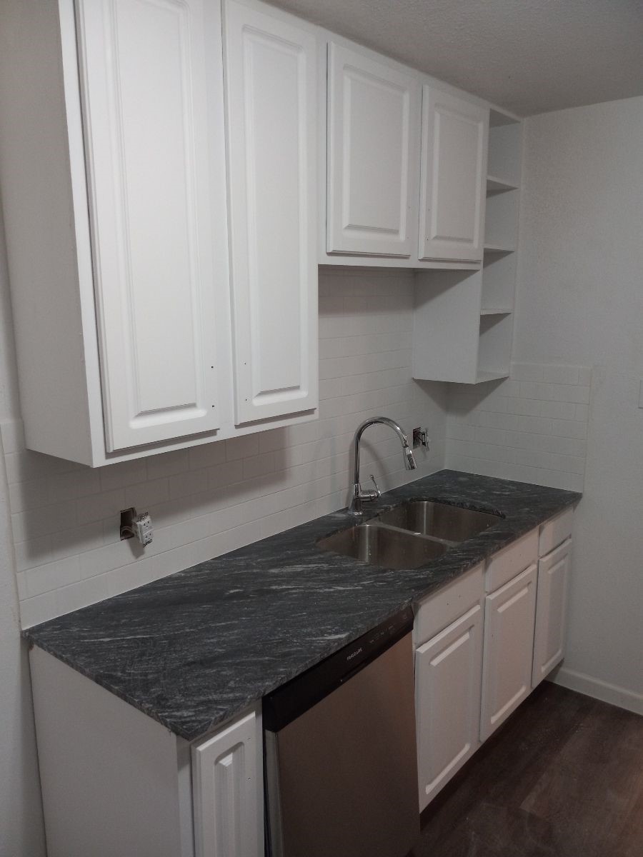 2681 Gessner Road, Unit 402 Houston, TX 77080 - Photo 1 of 11 a kitchen with granite countertop a sink dishwasher a stove and white cabinets
