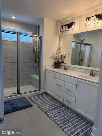 a bathroom with a sink a mirror and shower