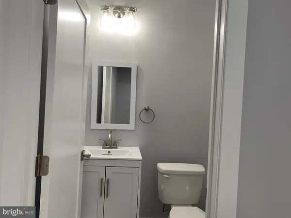 a bathroom with a toilet a sink and mirror