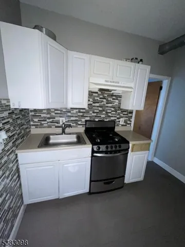 a white stove top oven sitting inside of a kitchen