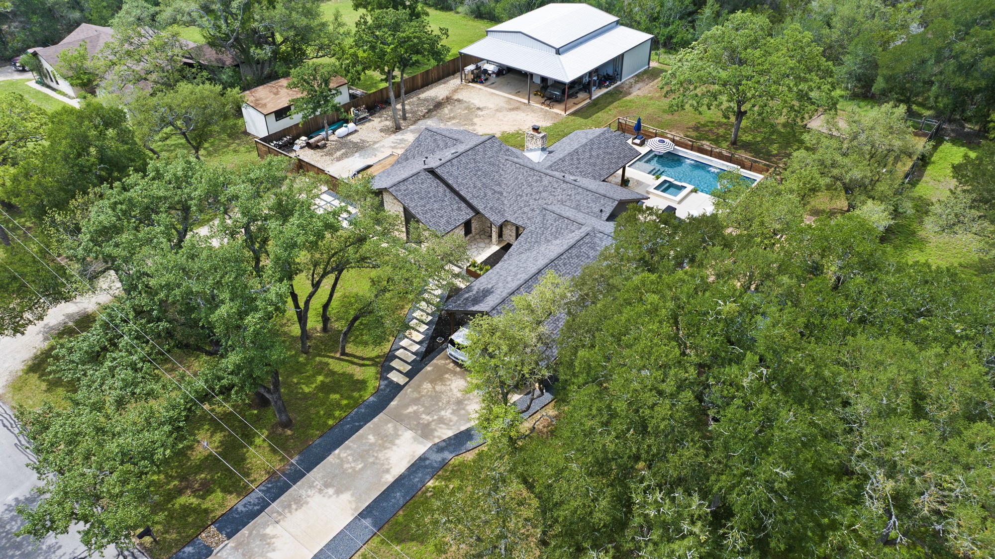 2802 Robin Road Manchaca, TX 78652 - Photo 40 of 40 Asymmetrical stone-clad residence featuring a multi-gabled roofline and an integrated swimming pool
