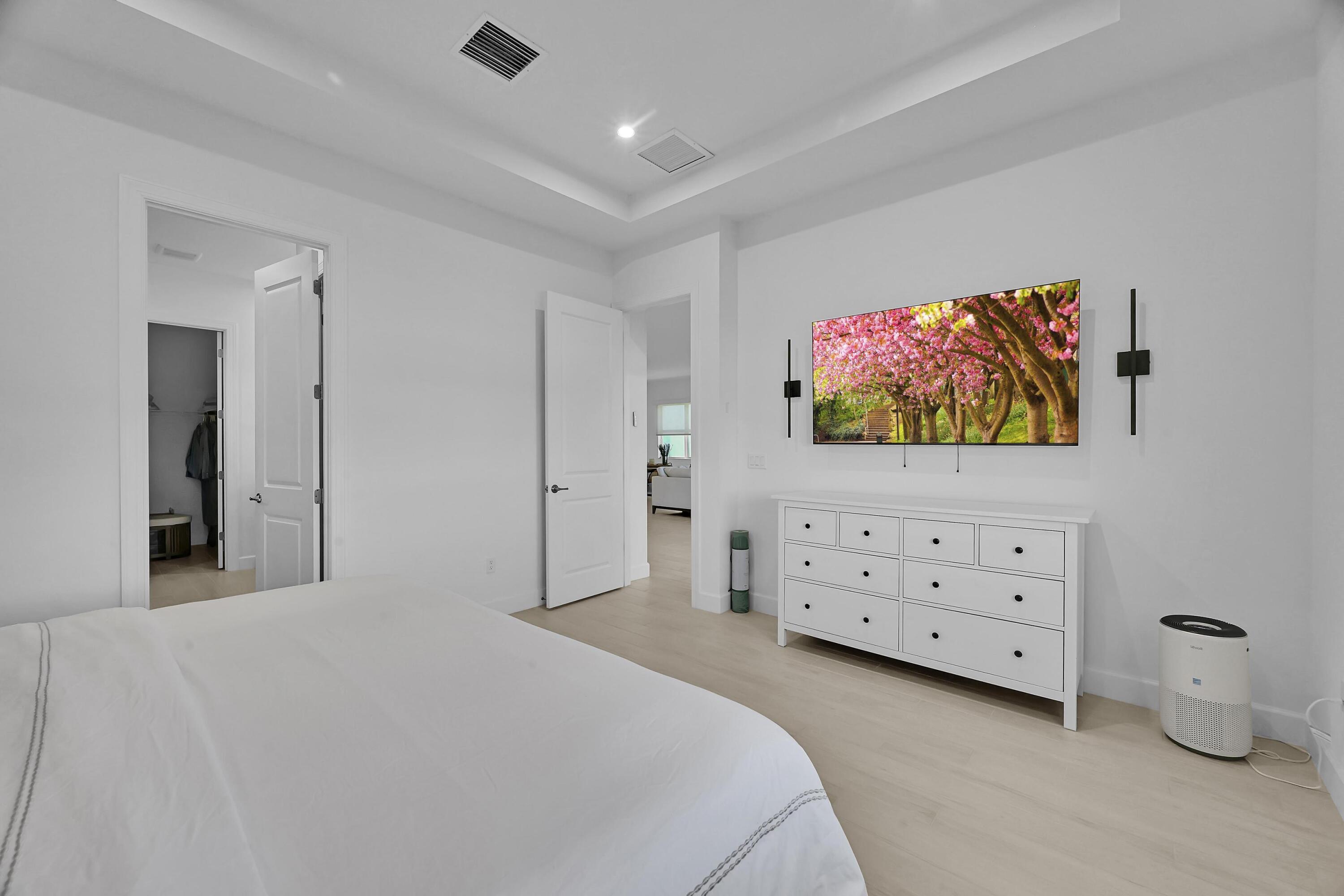 14185 Southwest Daphne St Port Port St. Lucie, FL 34987 - Photo 13 of 46 a bedroom with a bed dresser and flat screen tv