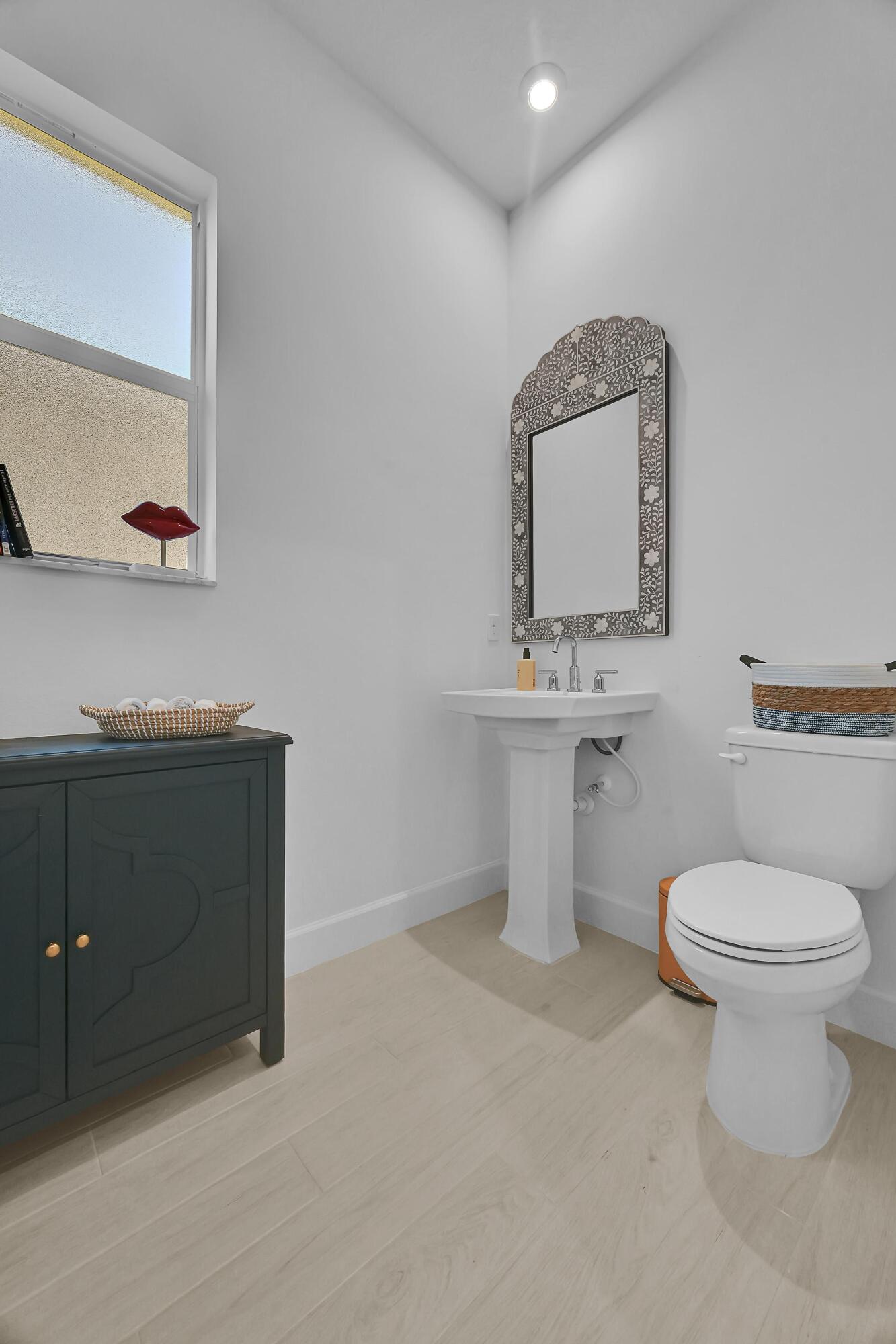 14185 Southwest Daphne St Port Port St. Lucie, FL 34987 - Photo 22 of 46 a bathroom with a toilet sink and mirror