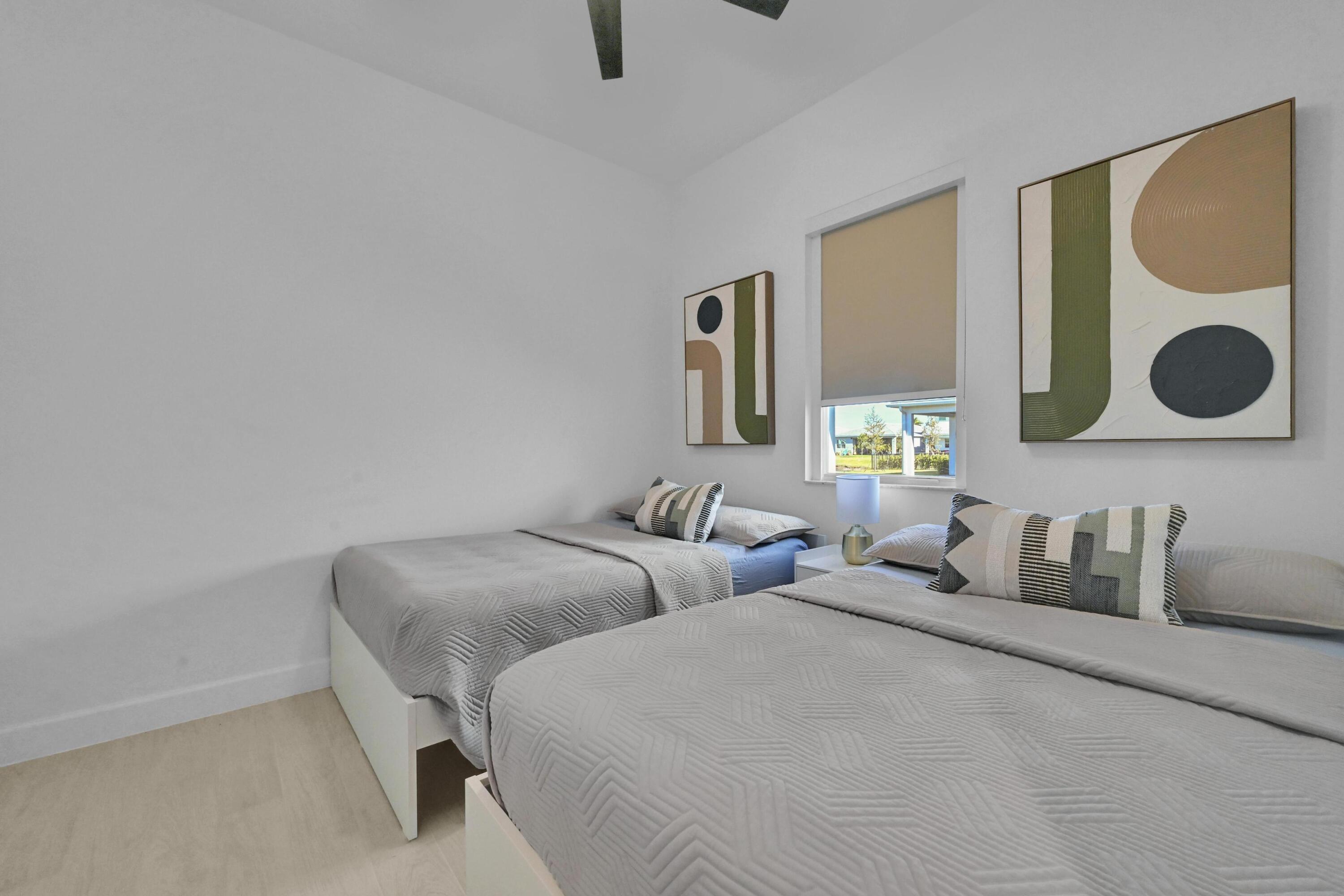 14185 Southwest Daphne St Port Port St. Lucie, FL 34987 - Photo 23 of 46 a bedroom with two beds and painting on the wall