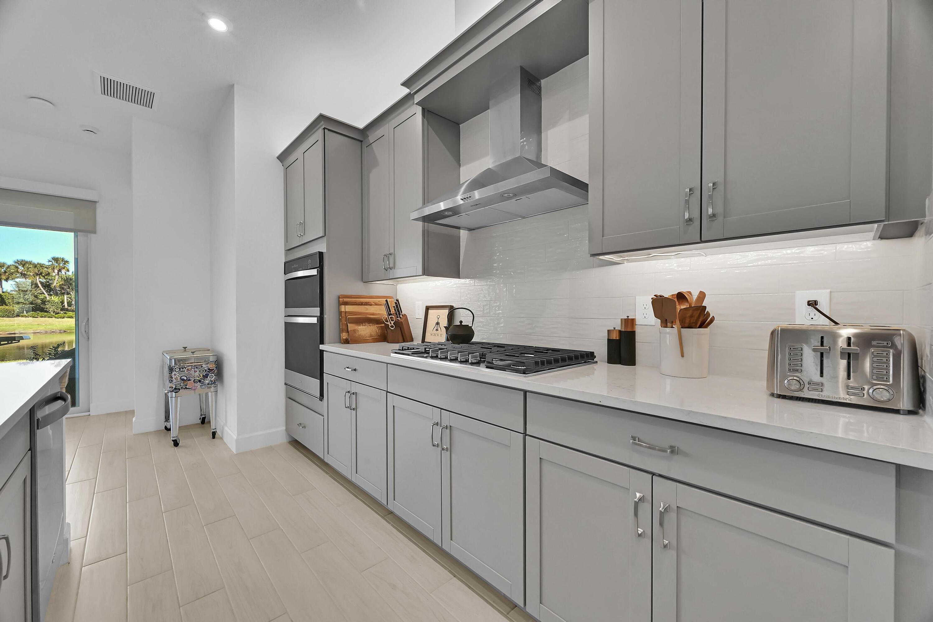 14185 Southwest Daphne St Port Port St. Lucie, FL 34987 - Photo 4 of 46 a kitchen with stainless steel appliances granite countertop a sink dishwasher stove and cabinets