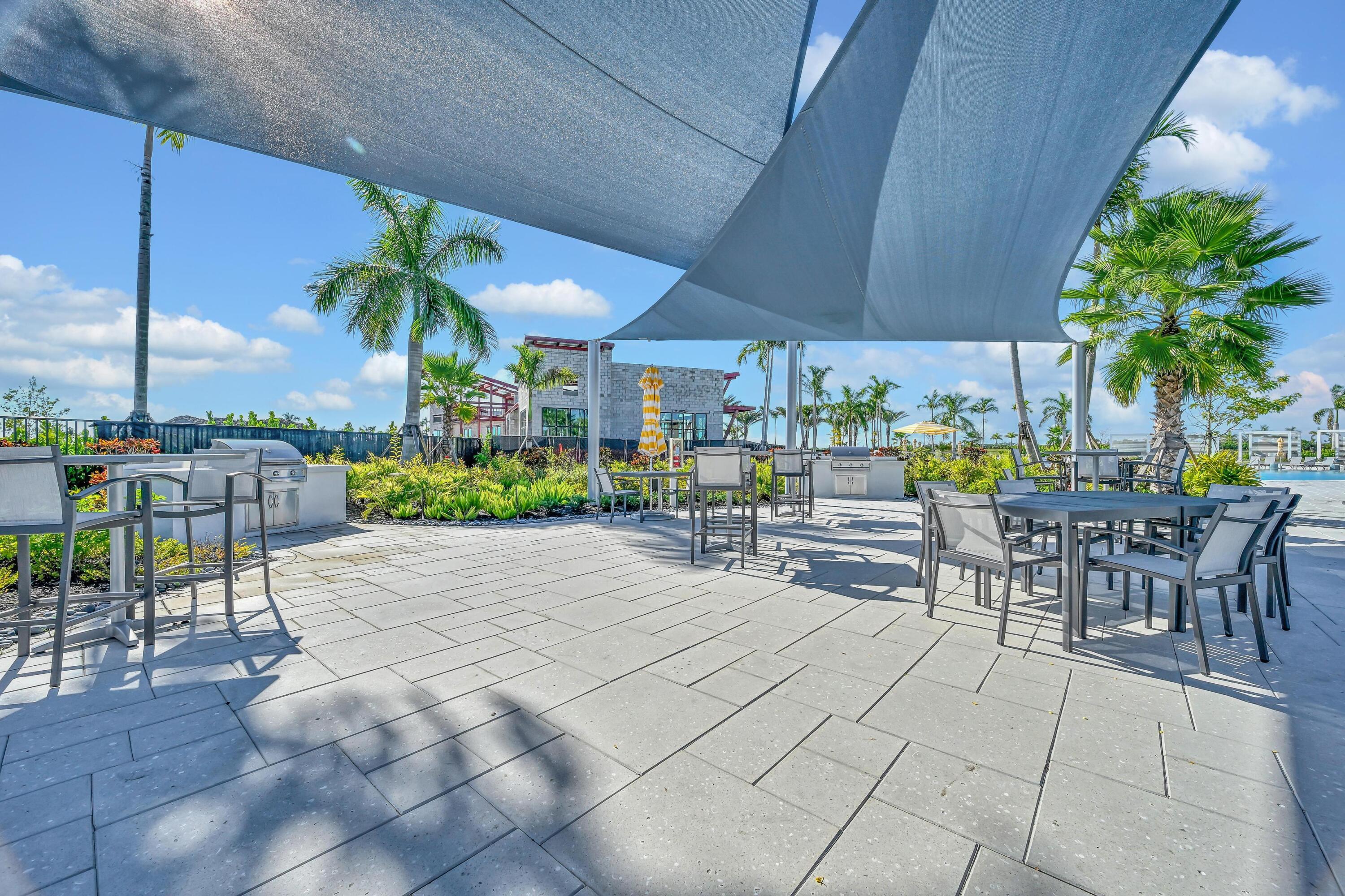 14185 Southwest Daphne St Port Port St. Lucie, FL 34987 - Photo 42 of 46 a view of a patio with a table and chairs under an umbrella with a patio