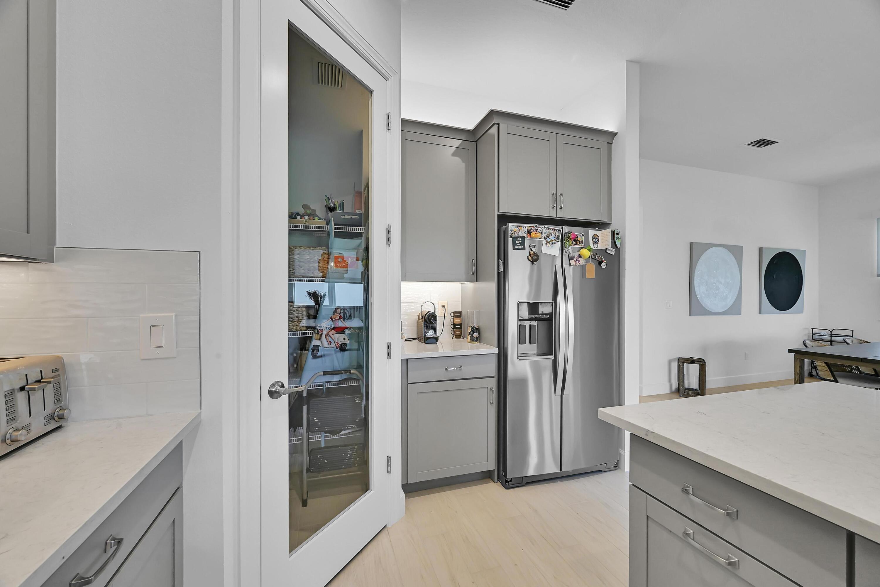 14185 Southwest Daphne St Port Port St. Lucie, FL 34987 - Photo 6 of 46 a kitchen with stainless steel appliances a refrigerator and a sink