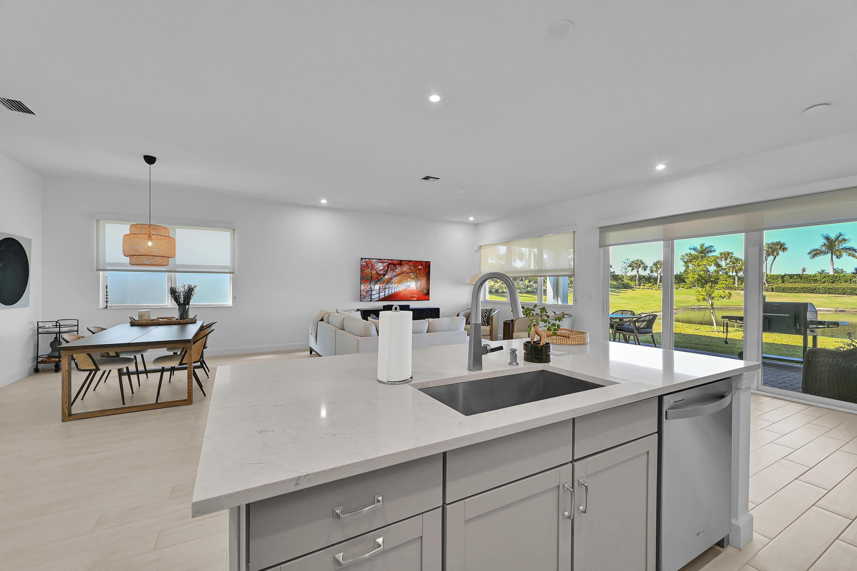 14185 Southwest Daphne St Port Port St. Lucie, FL 34987 - Photo 7 of 46 a kitchen with granite countertop a sink and white cabinets with wooden floor