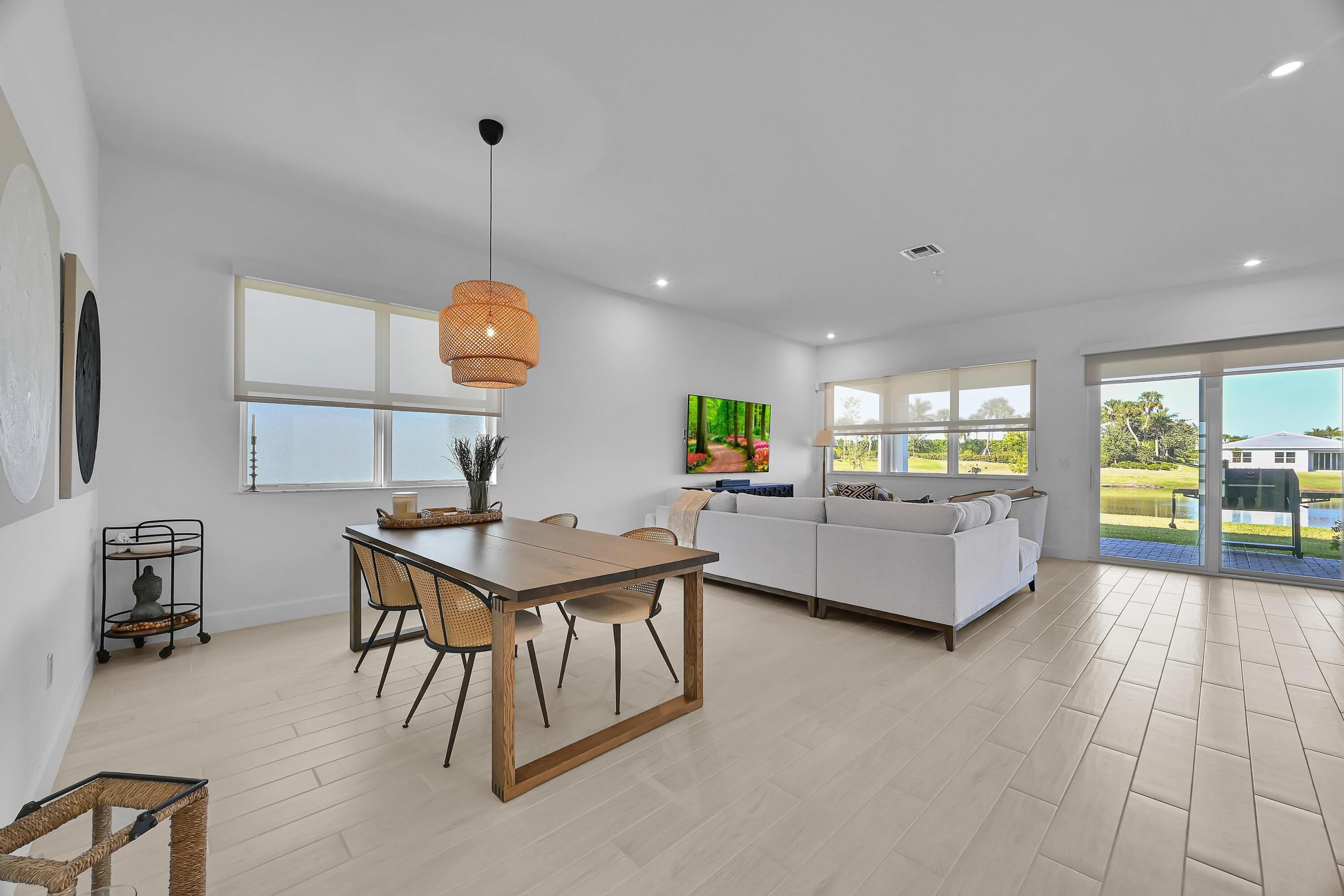 14185 Southwest Daphne St Port Port St. Lucie, FL 34987 - Photo 9 of 46 a living room with couches and kitchen view with wooden floor