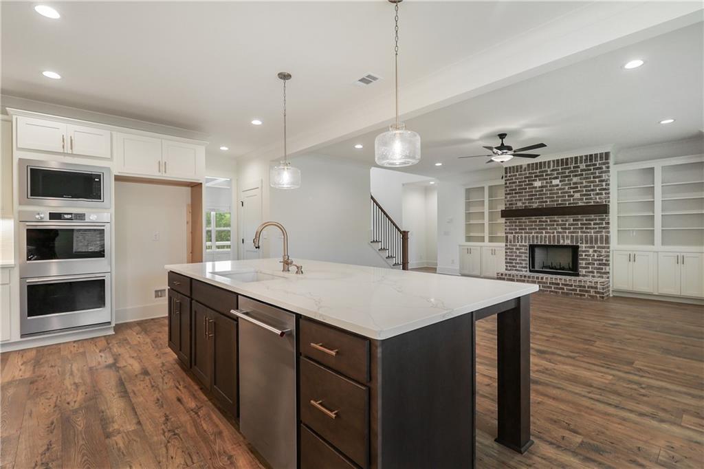 2113 Stonegate Way Monroe, GA 30656 - Photo 23 of 43 a large kitchen with a sink a stove and a wooden floors