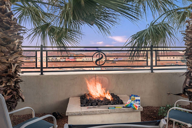 2600 Ocotillo Way, Unit 31 Santa Clara, UT 84765 - Photo 39 of 73 Outdoor patio featuring a built-in fire pit with lava rocks, framed by mature palm trees