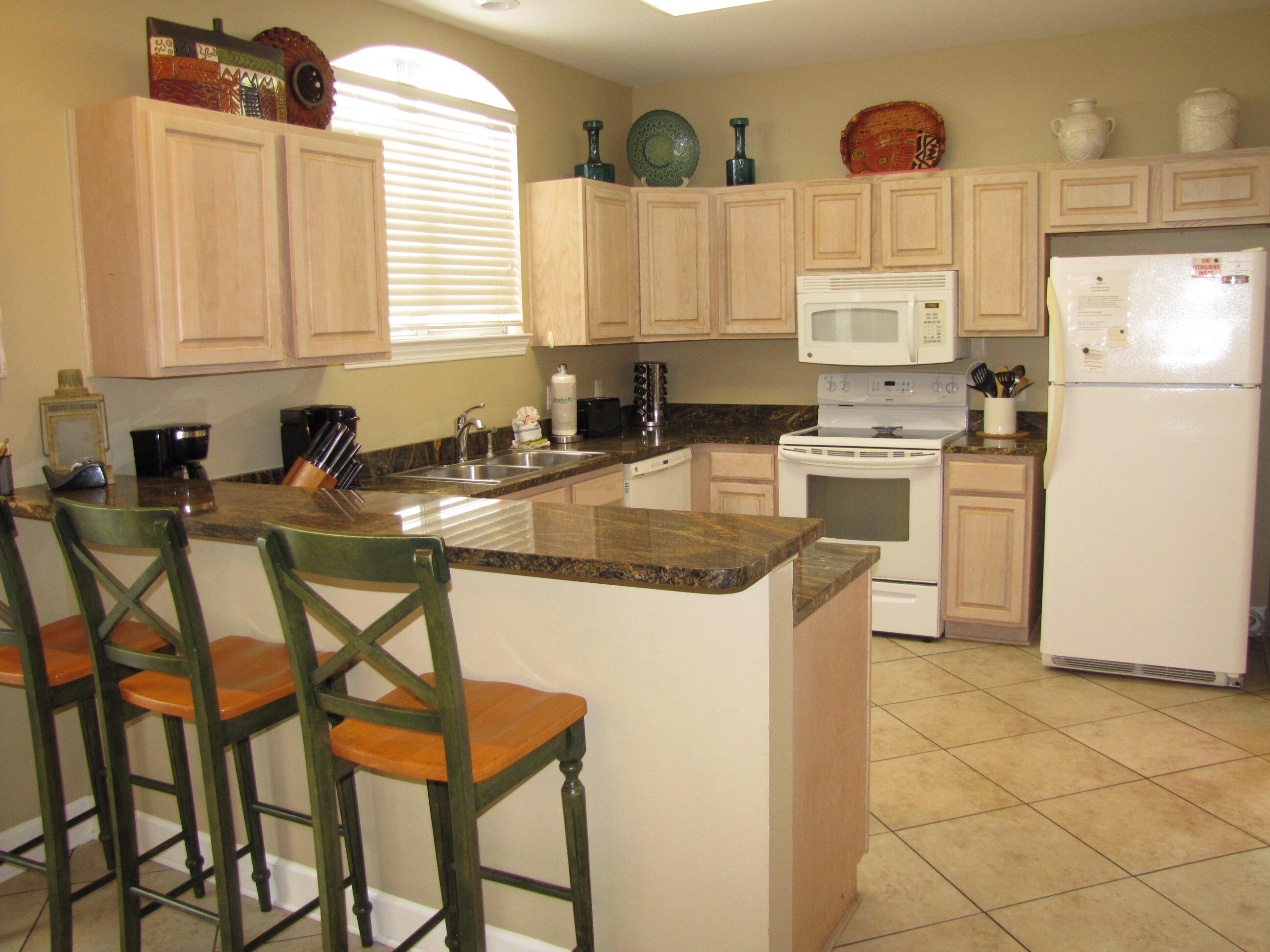 22 Amber Cove Miramar Beach, FL 32550 - Photo 6 of 60 a kitchen with stainless steel appliances granite countertop a table chairs sink refrigerator and cabinets