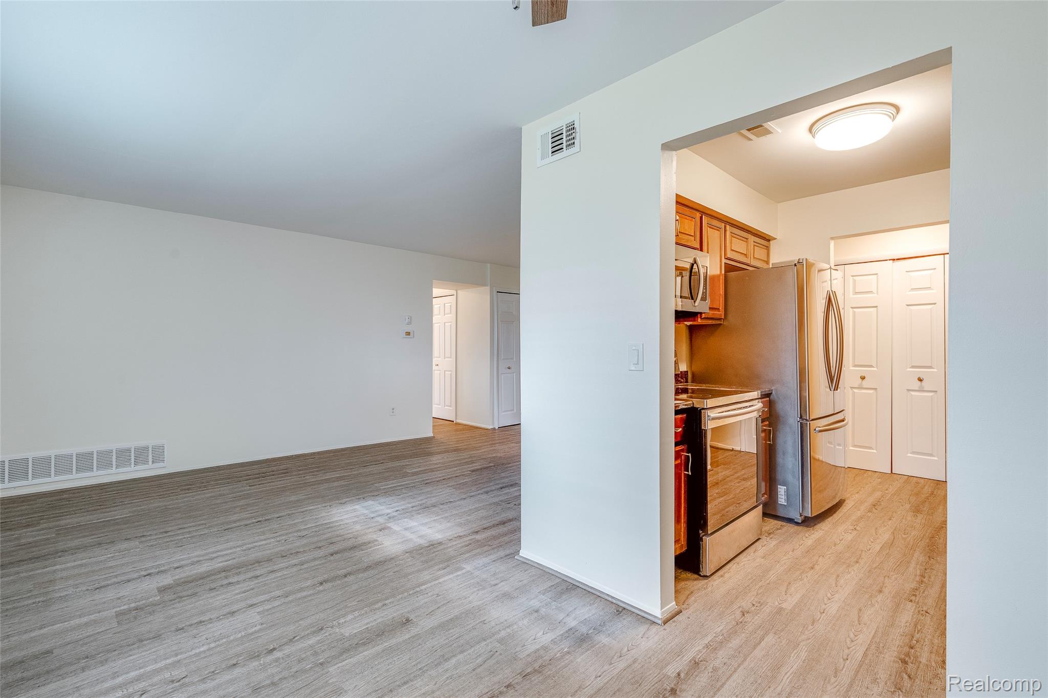 29860 West 12 Mile Road, Unit 604 Farmington, MI 48334 - Photo 7 of 26 Kitchen with wood finish cabinetry, stainless steel appliances, light wood-style floors, and light countertops